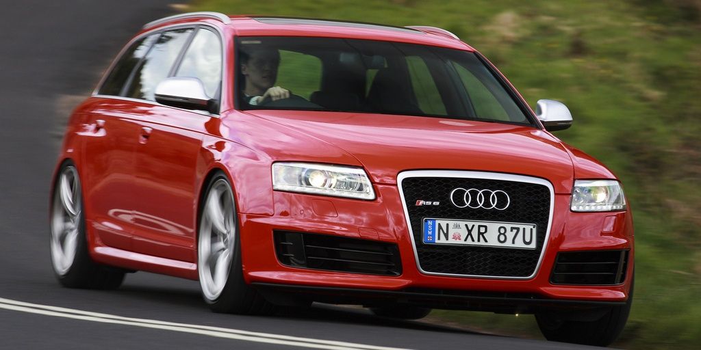 A red 2008 Audi RS6 Avant C6 speeding out of a corner