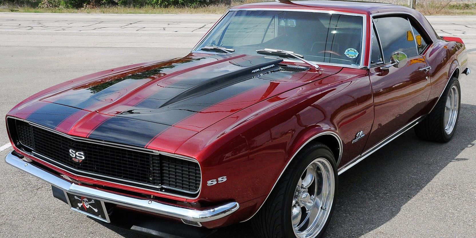 A red and black 1967 Chevrolet Camaro SS parked