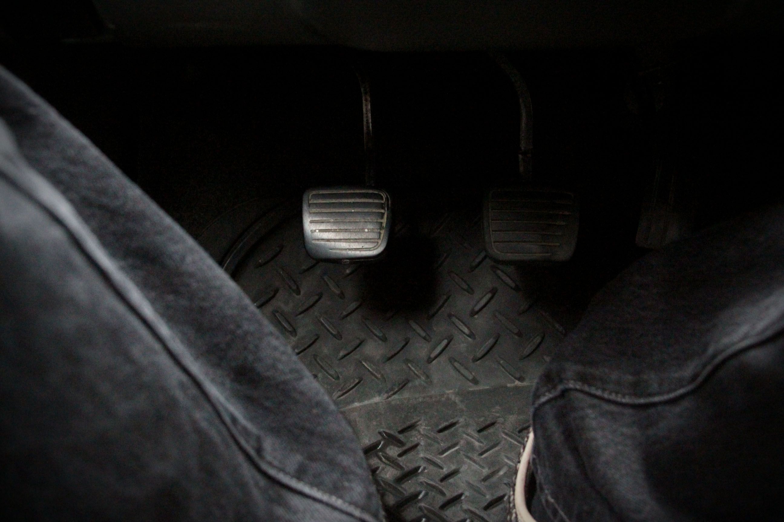 dual pedals on floor of dimly-lit car