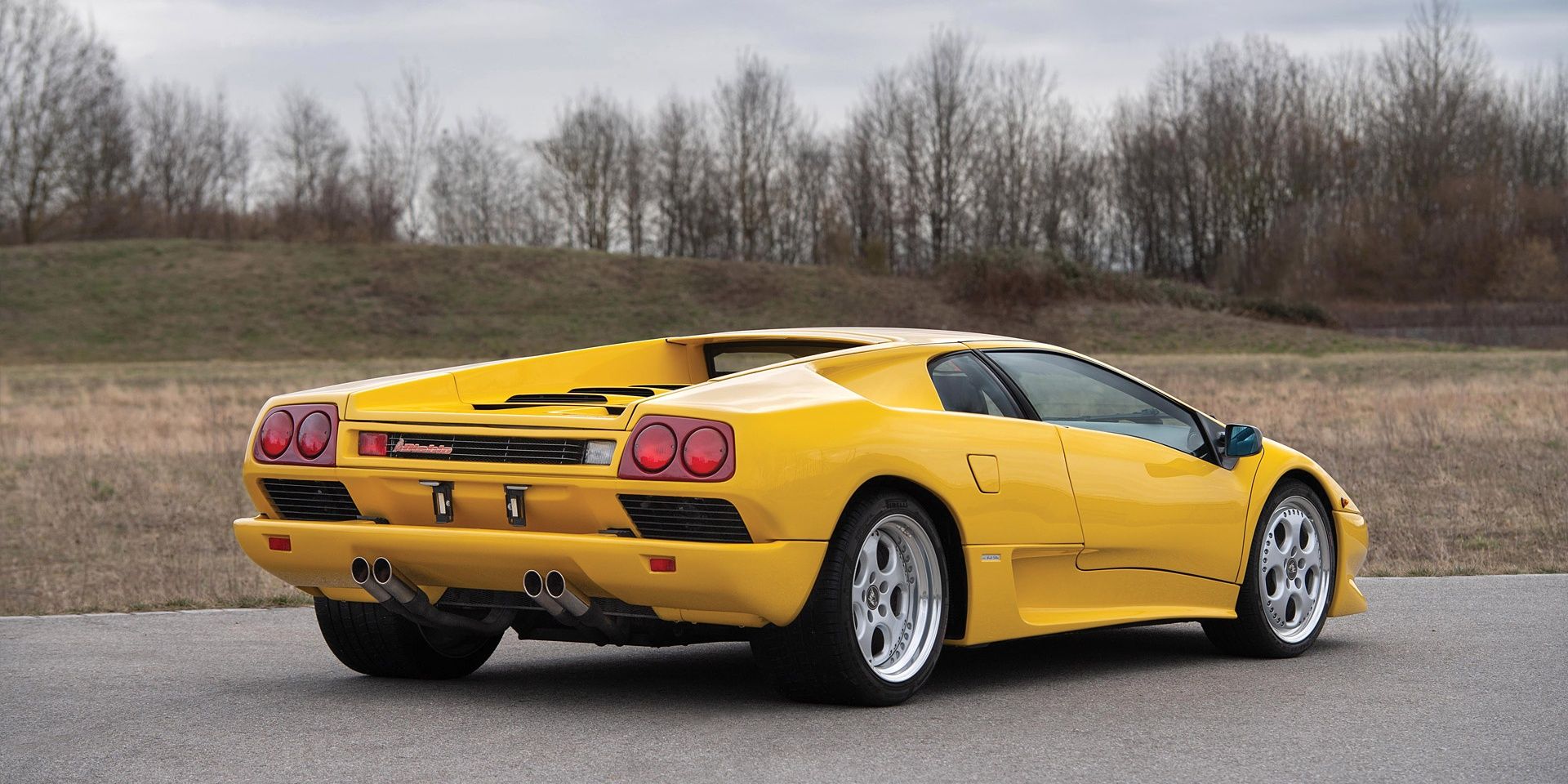 The back side picture of a yellow 1990 Lamborghini Diablo