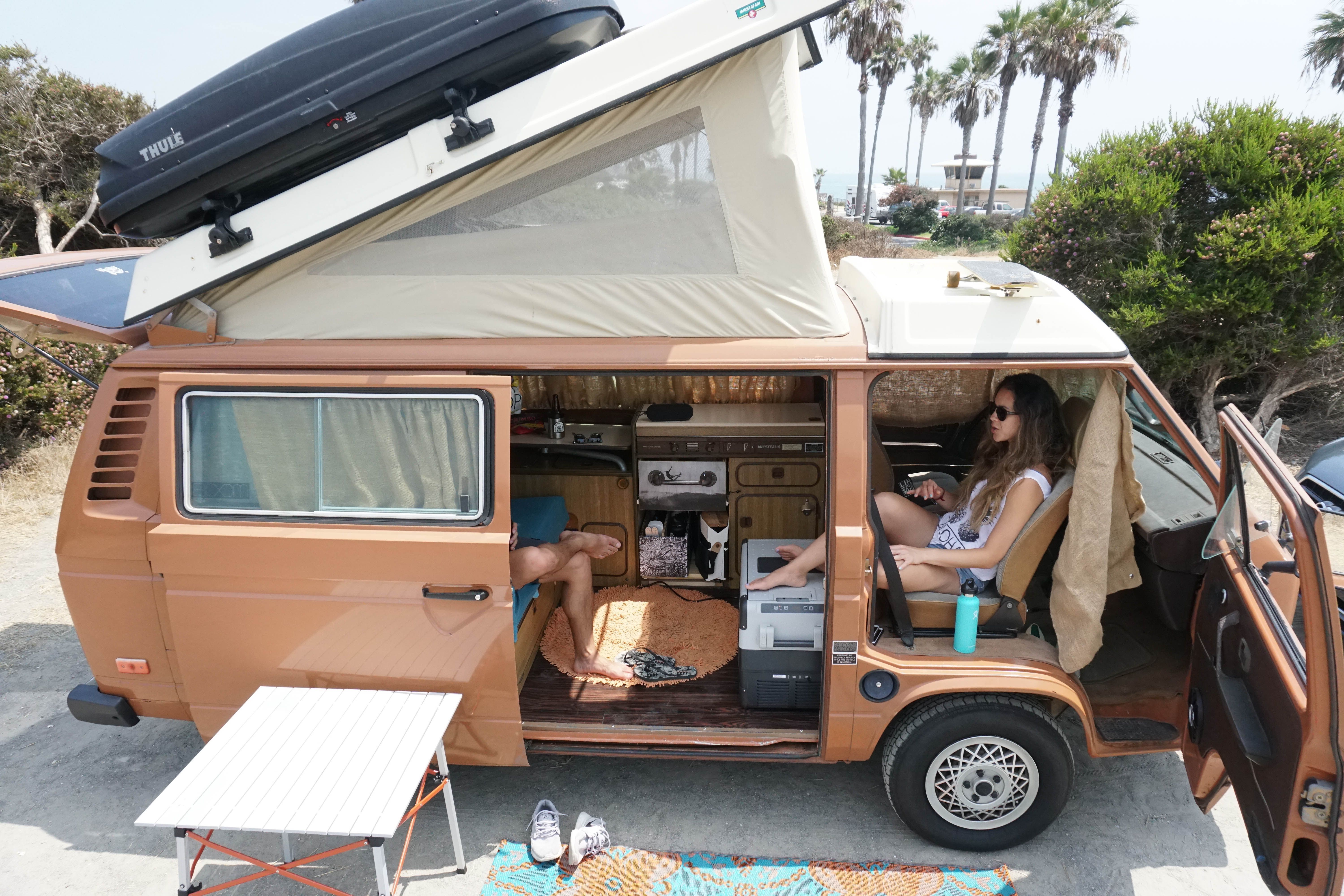 Relaxing at a camp site in a VW Westfalia with the pop-top up