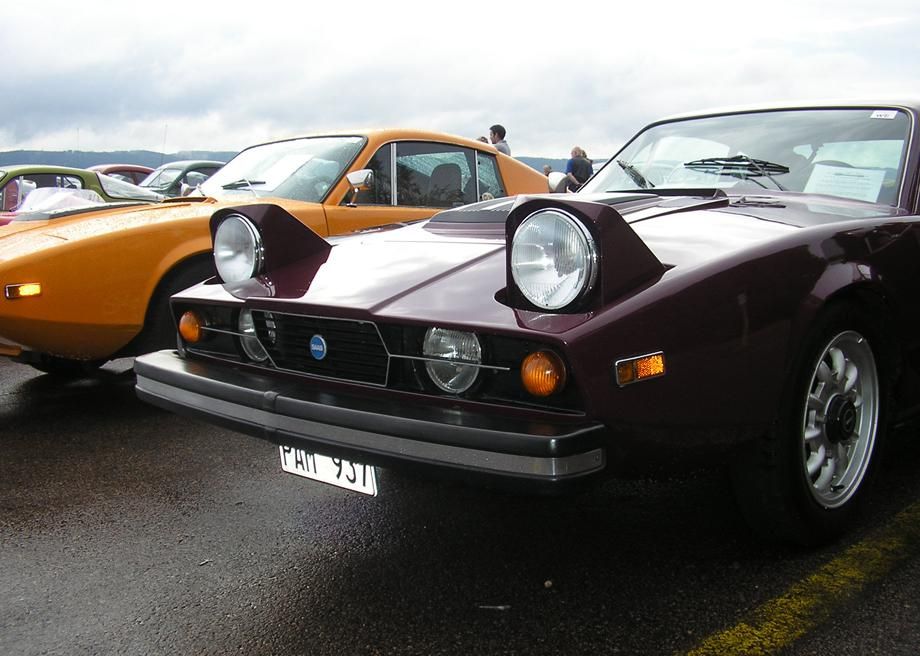 A 1973 Saab Sonett II car with pop-up headlights stands parked.