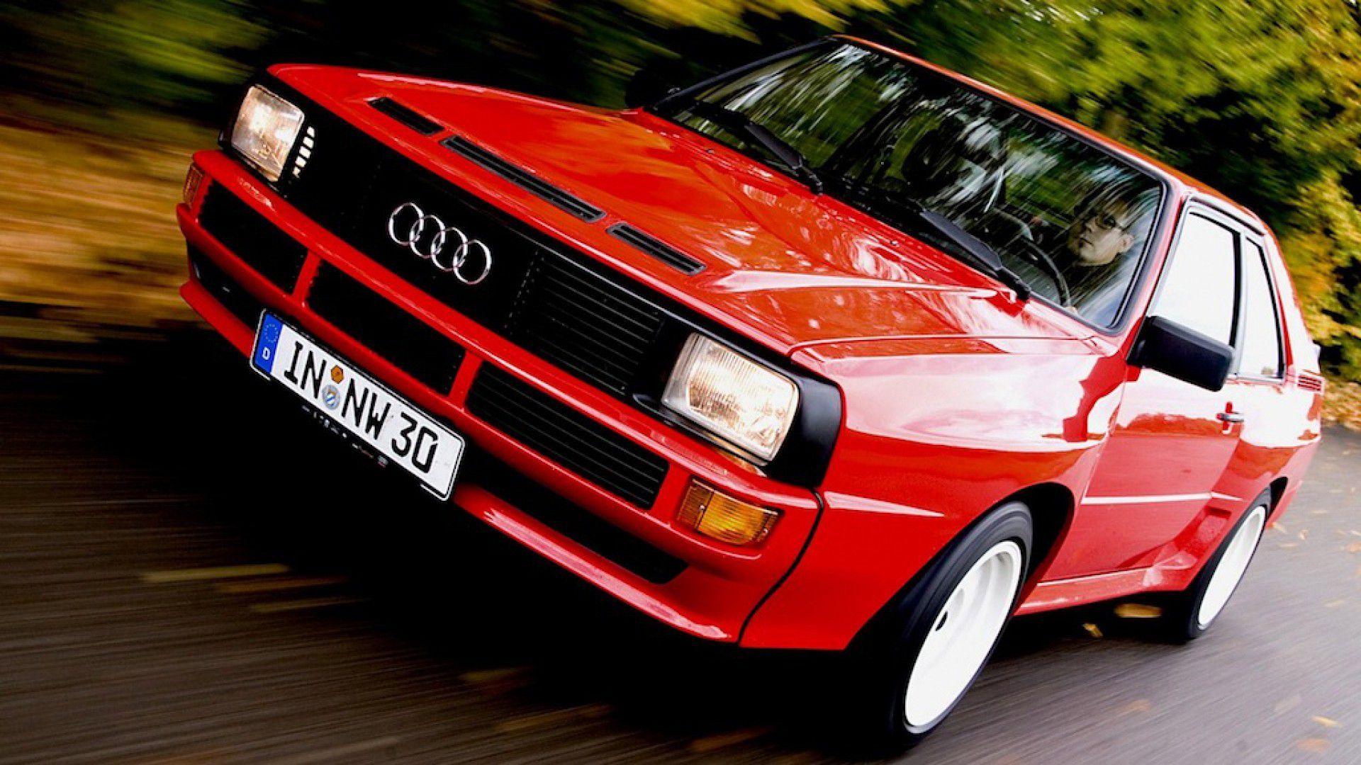 red Audi Quattro Sport speeding on the road