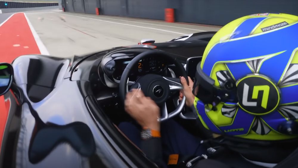 F1 racer Lando Norris charges out of the pits in a McLaren Elva