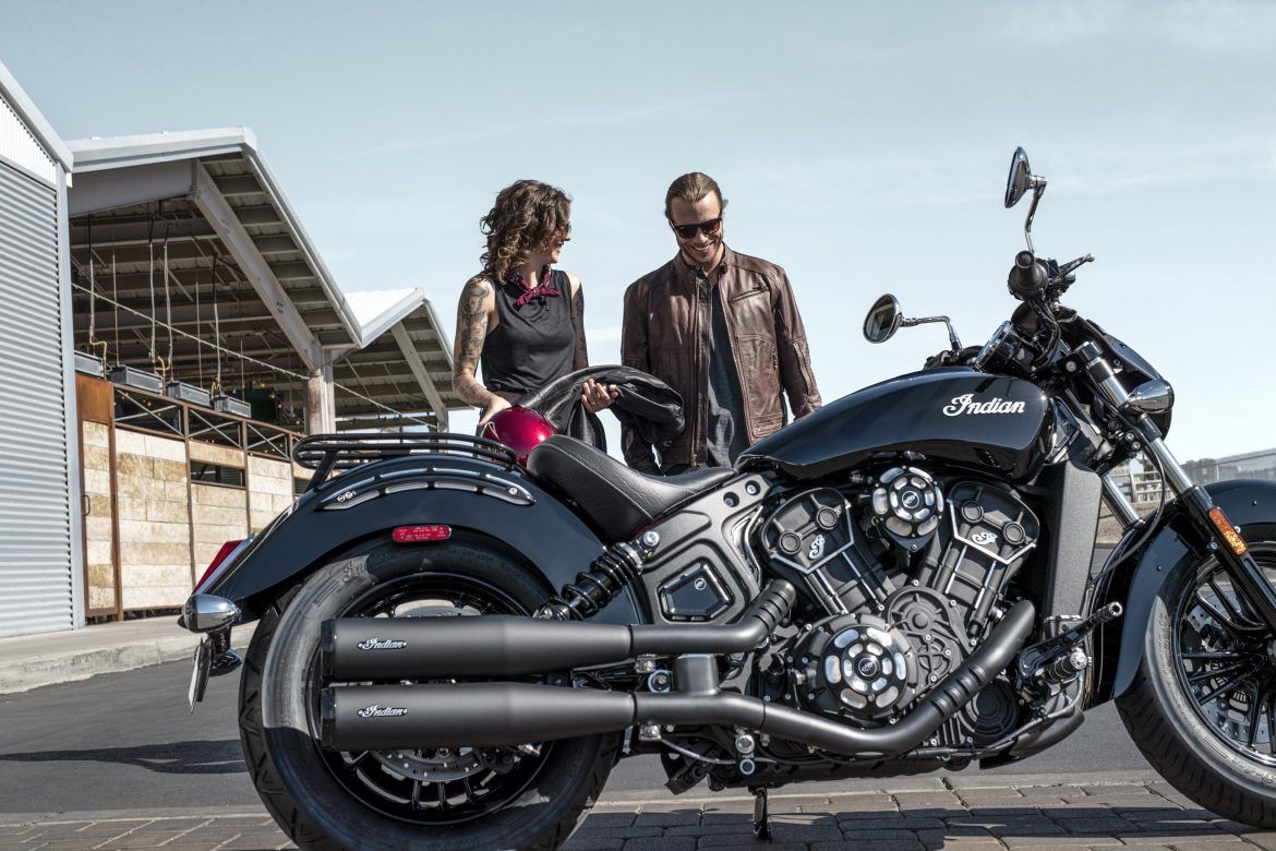riders standing next to an Indian Scout Sixty