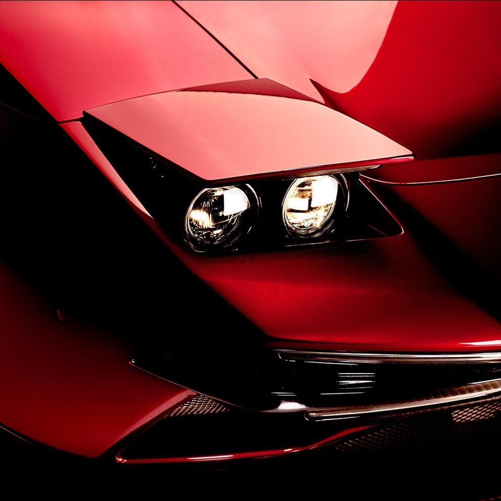 The pop-up headlight of a red Ares Panther car.