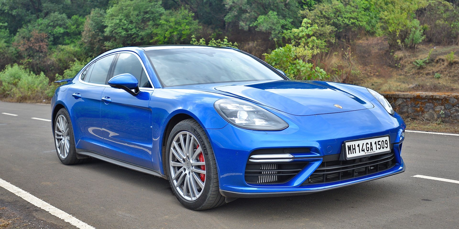 A blue Porsche Panamera Diesel Turbo parked in the middle of the road