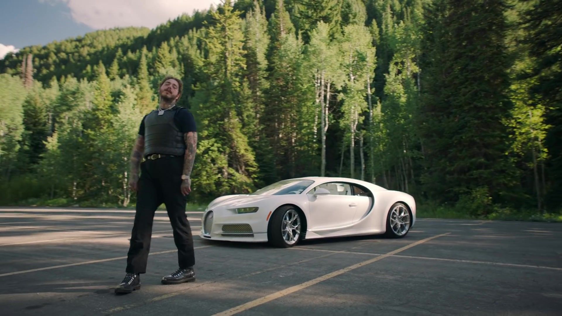 Post Malone walks alongside his white Bugatti Chiron