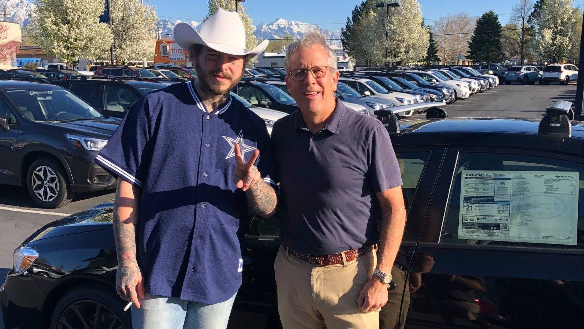 Post Malone poses with a fan in front of a 2019 Subaru WRX
