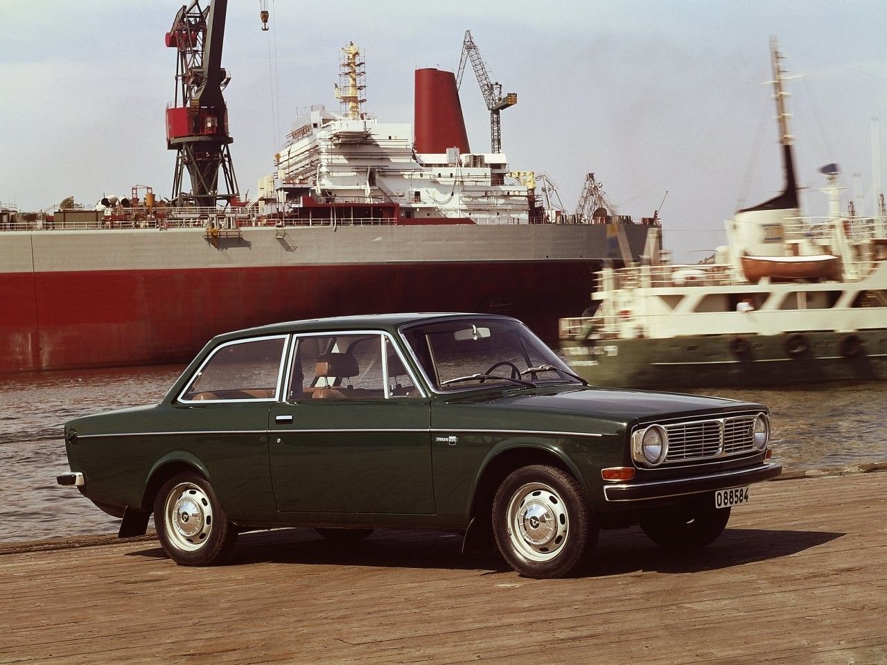green Volvo 142 at sea in old photo