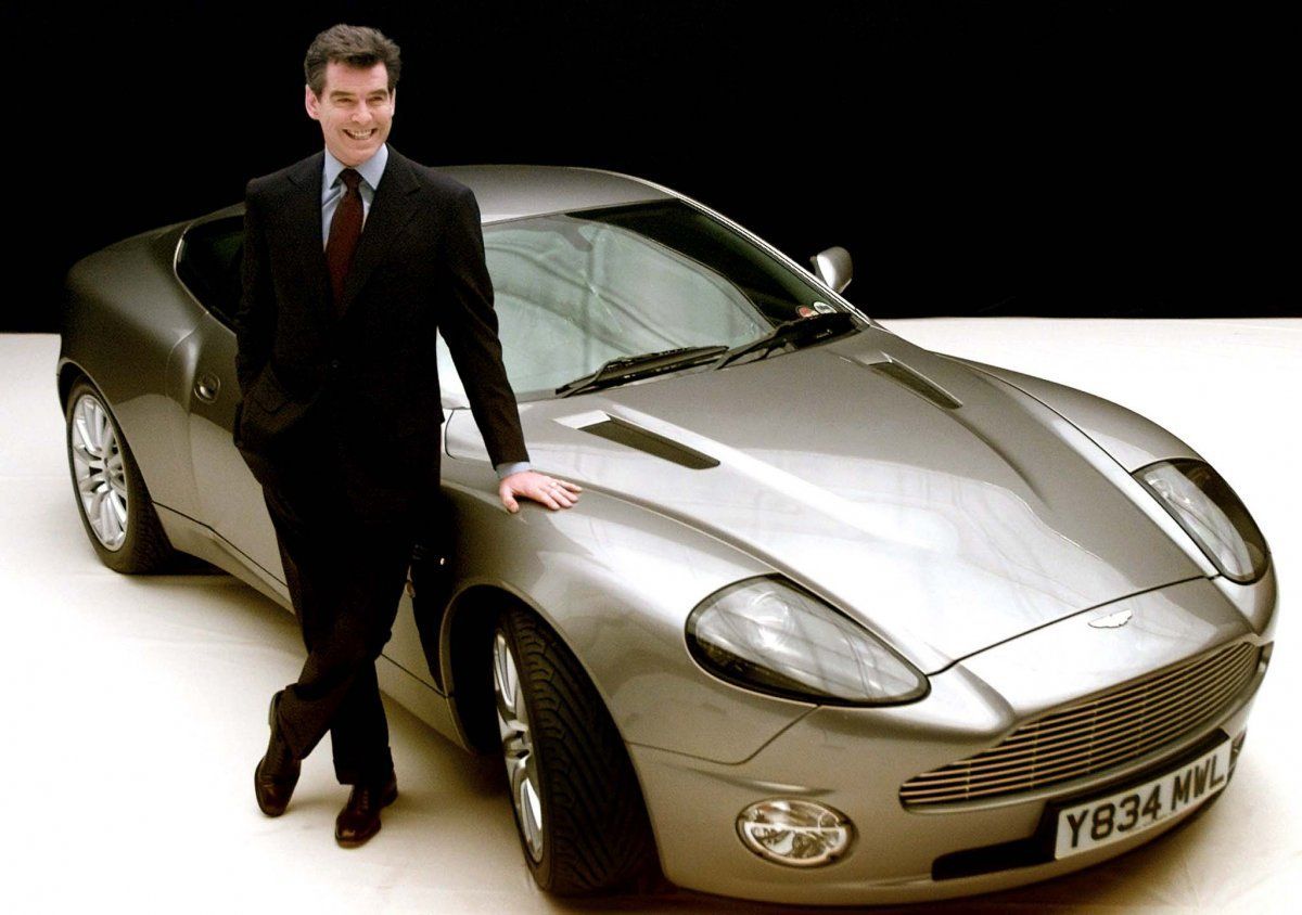 Piers Brosnan stands with the Aston Martin V12 Vanquish