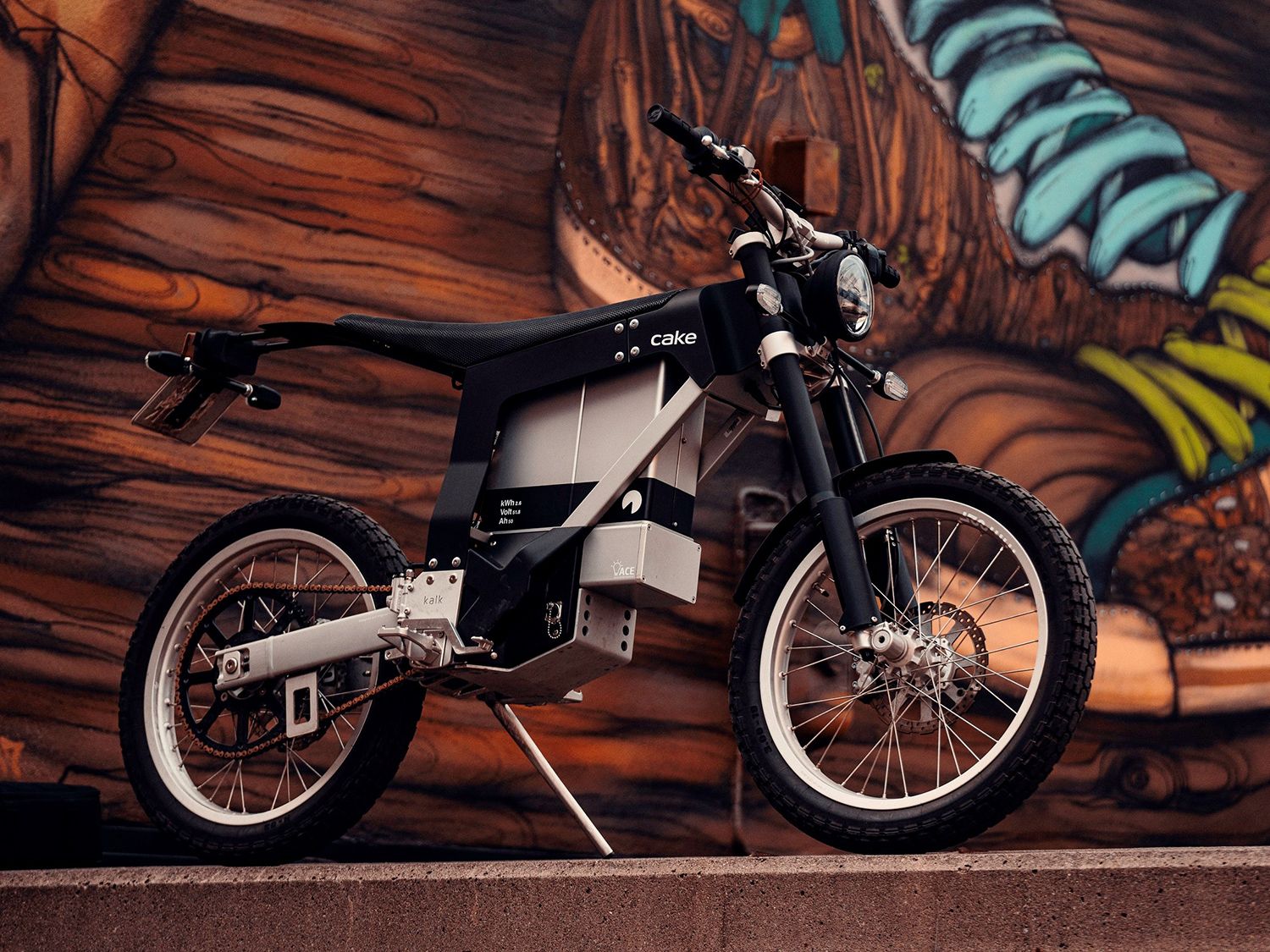 A Cake Kalk INK electric motorcycle sits on a ledge.