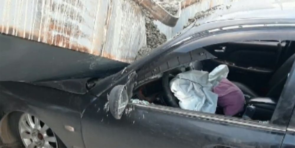Close-up of car front end crushed by bridge beam