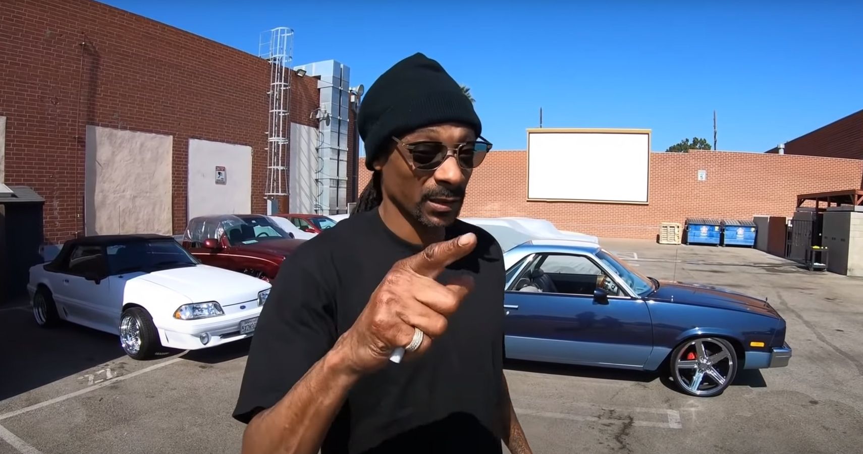 Snoop Dogg poses and points by his El Camino