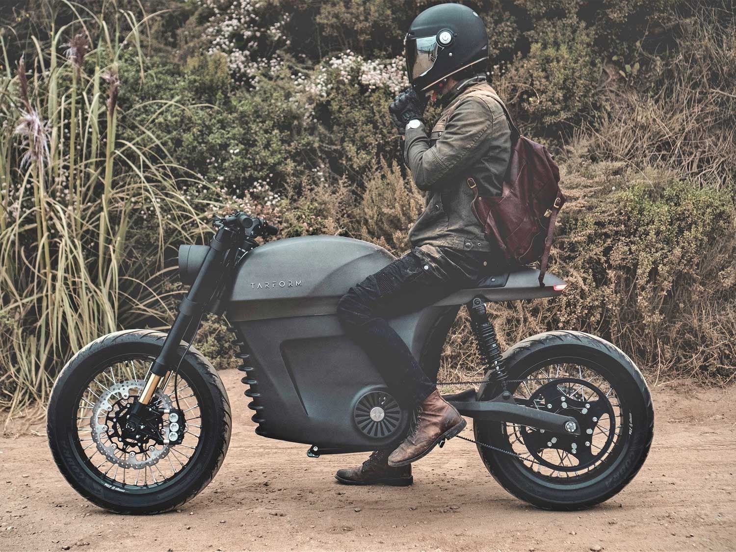 The Tarform Luna Electric Motorcycle on a dirt road.