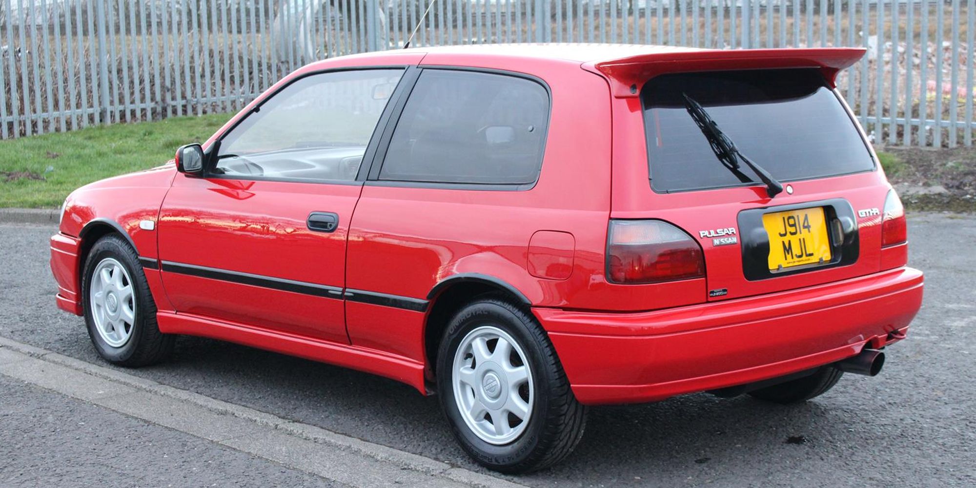 Rear 3/4 view of a red Pulsar GTI-R