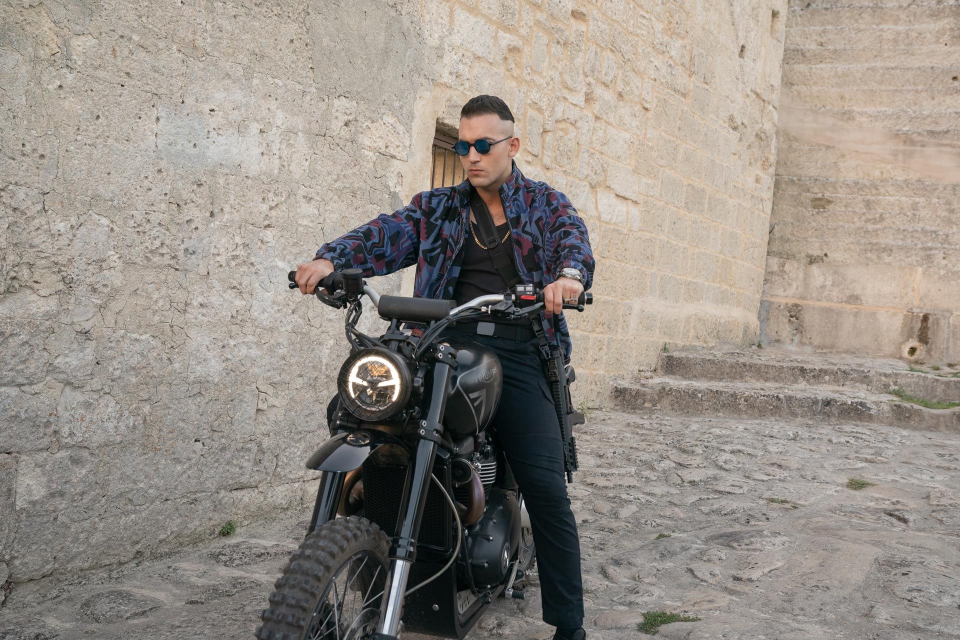 This is a henchman named Primo riding a Triumph Scrambler 1200 XE in Matera Italy during No Time To Die