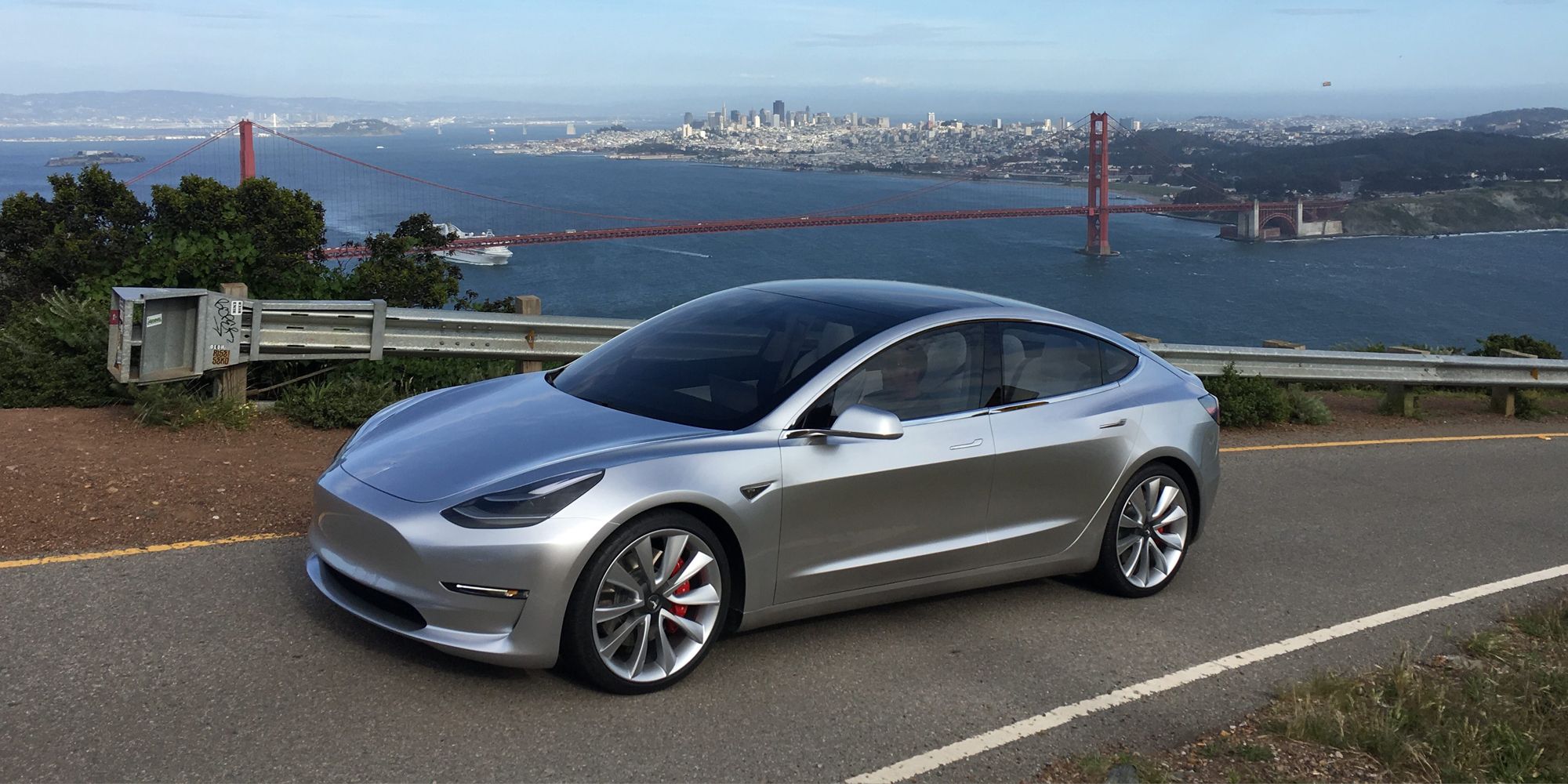 A silver Model 3 Performance on a hill