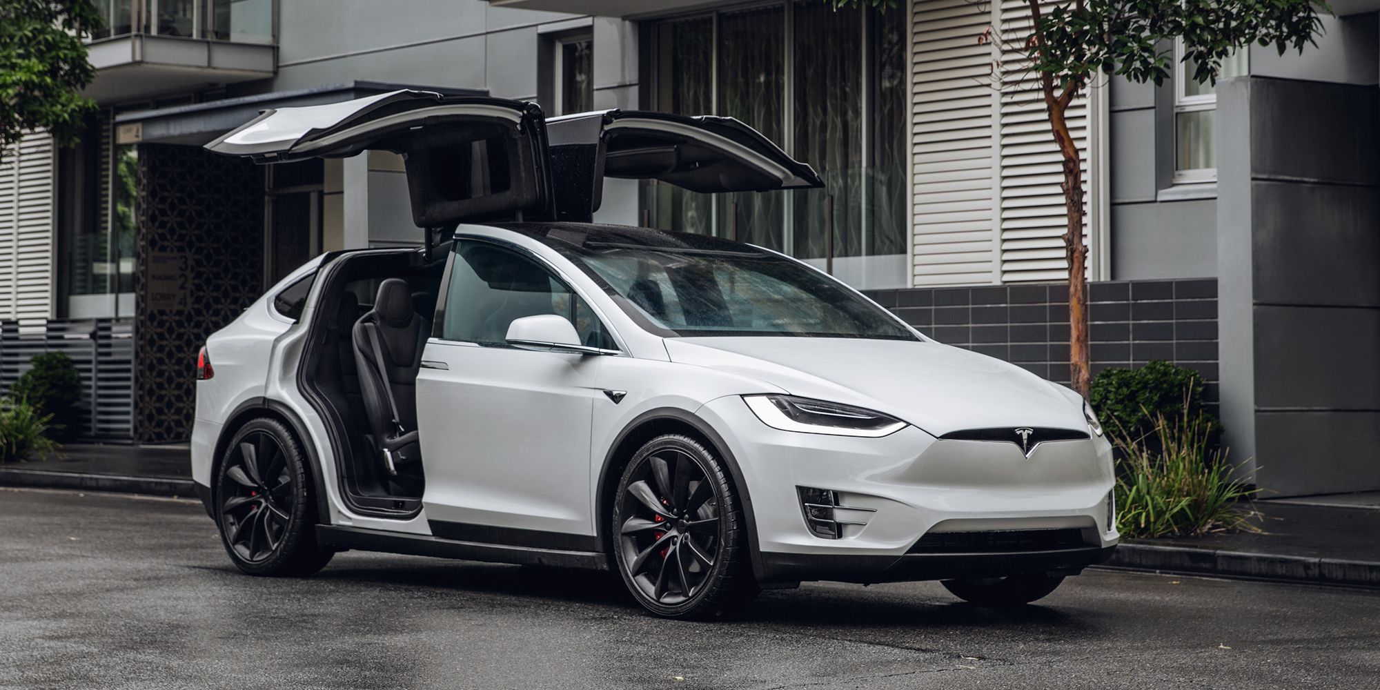 A white Model X with the falcon doors up