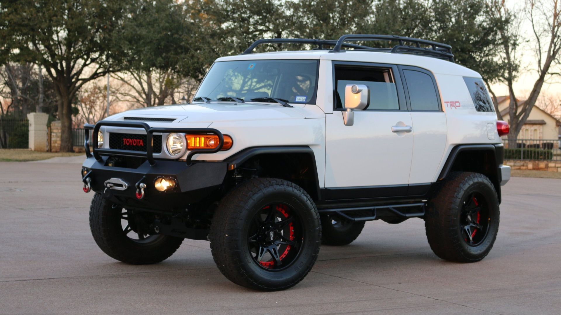White Toyota FJ Cruiser from side with lights on