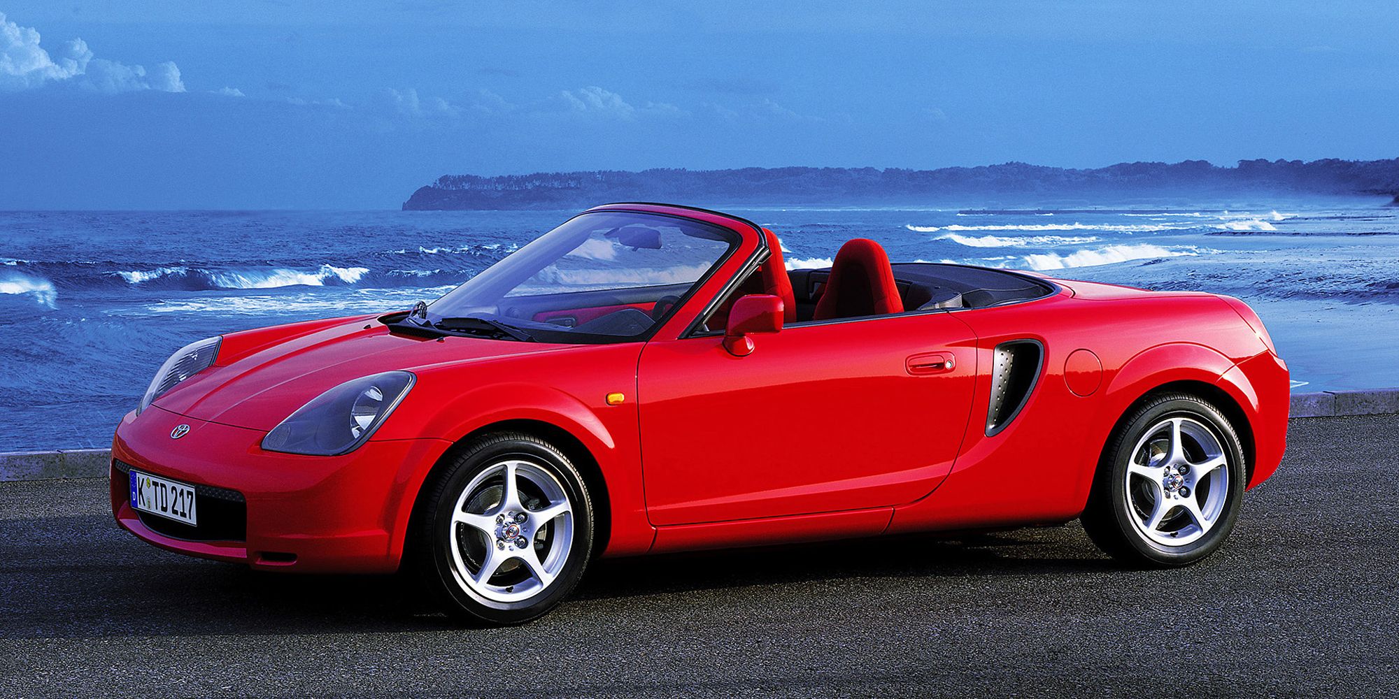 A red MR2 Spyder with the top down