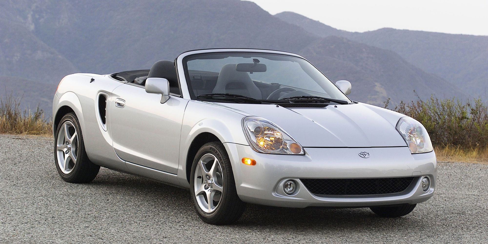 A silver MR2 Spyder with the top down