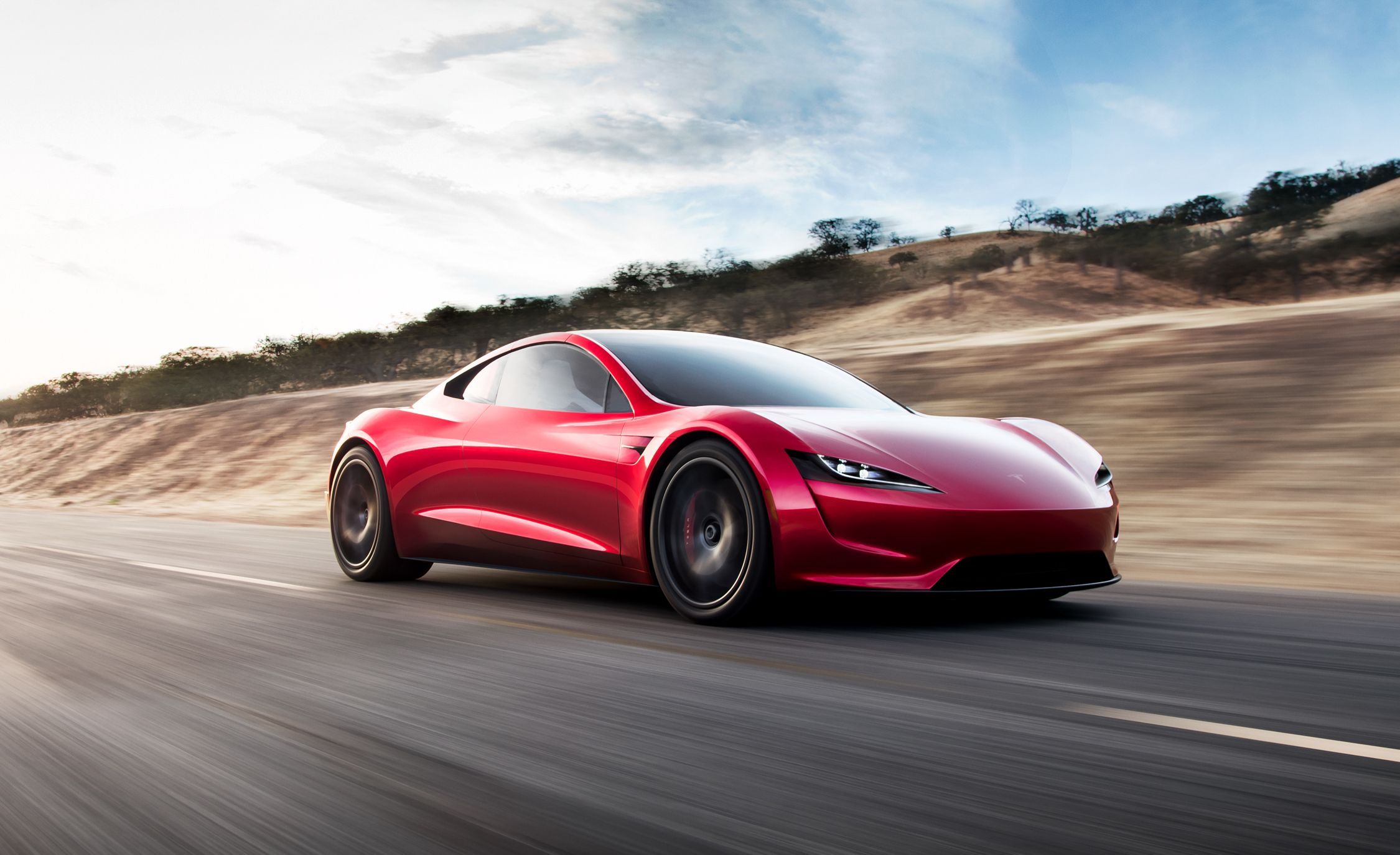 Red 2021 Tesla Roadster racing down road