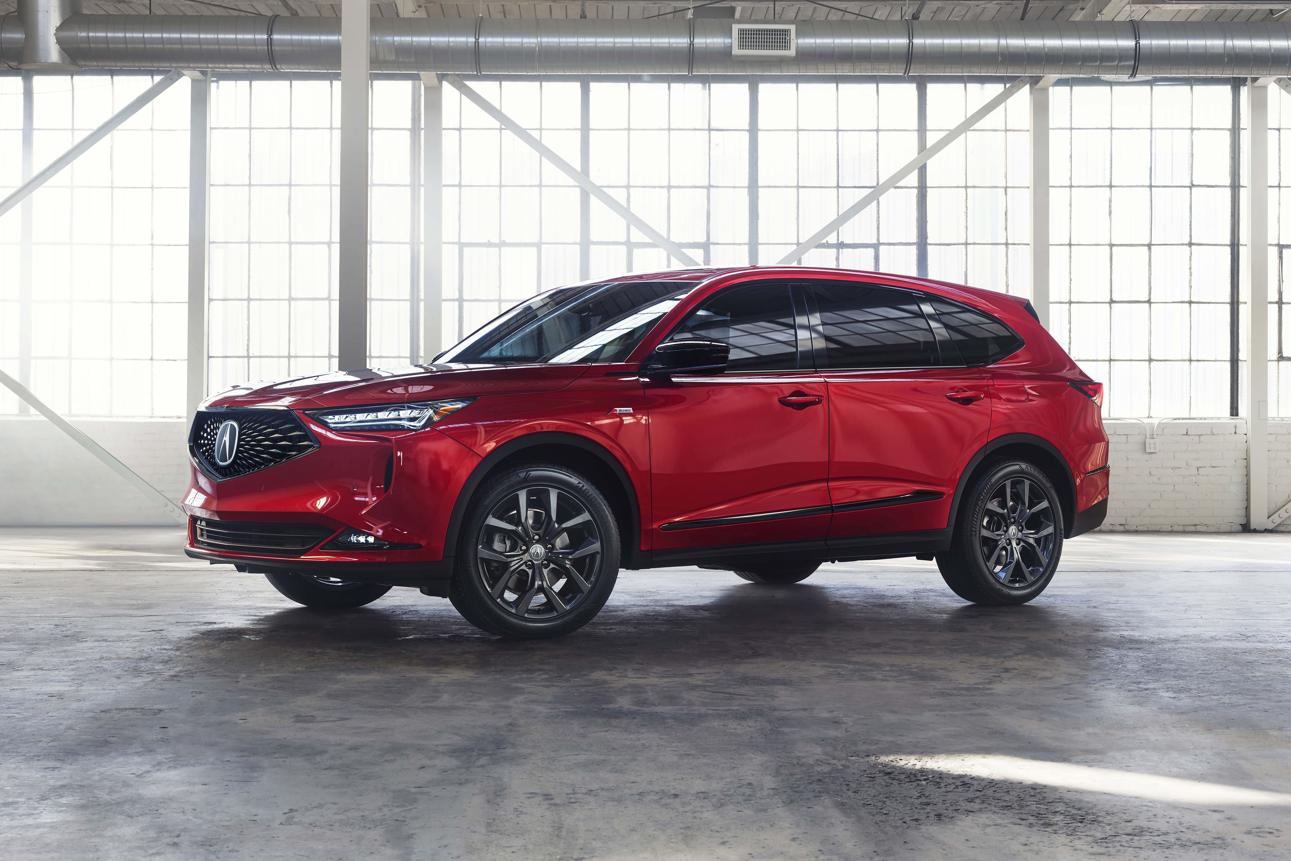 A red 2022 Acura MDX stands parked inside a warehouse.