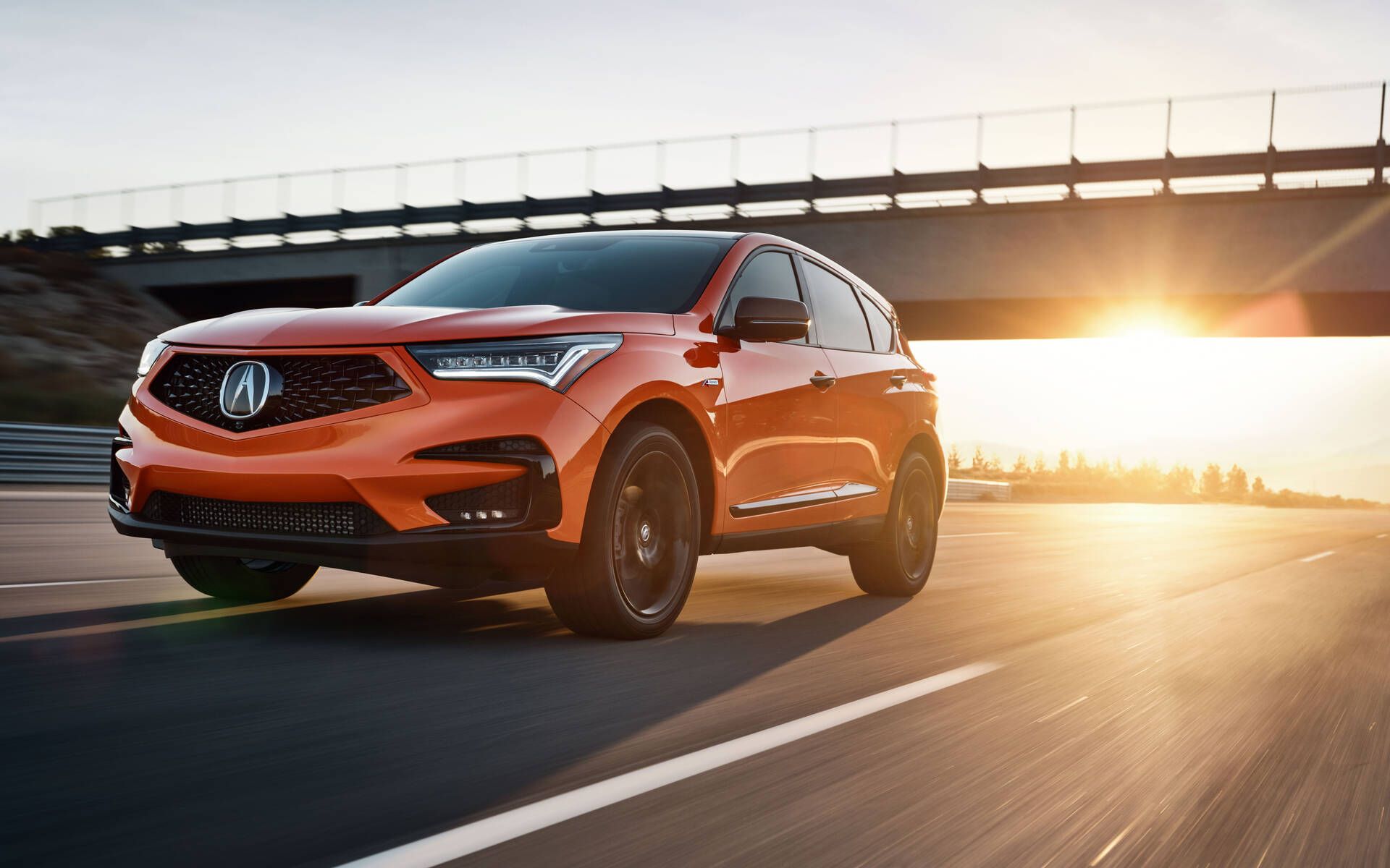 The Acura RDX driving with a low sun in the background