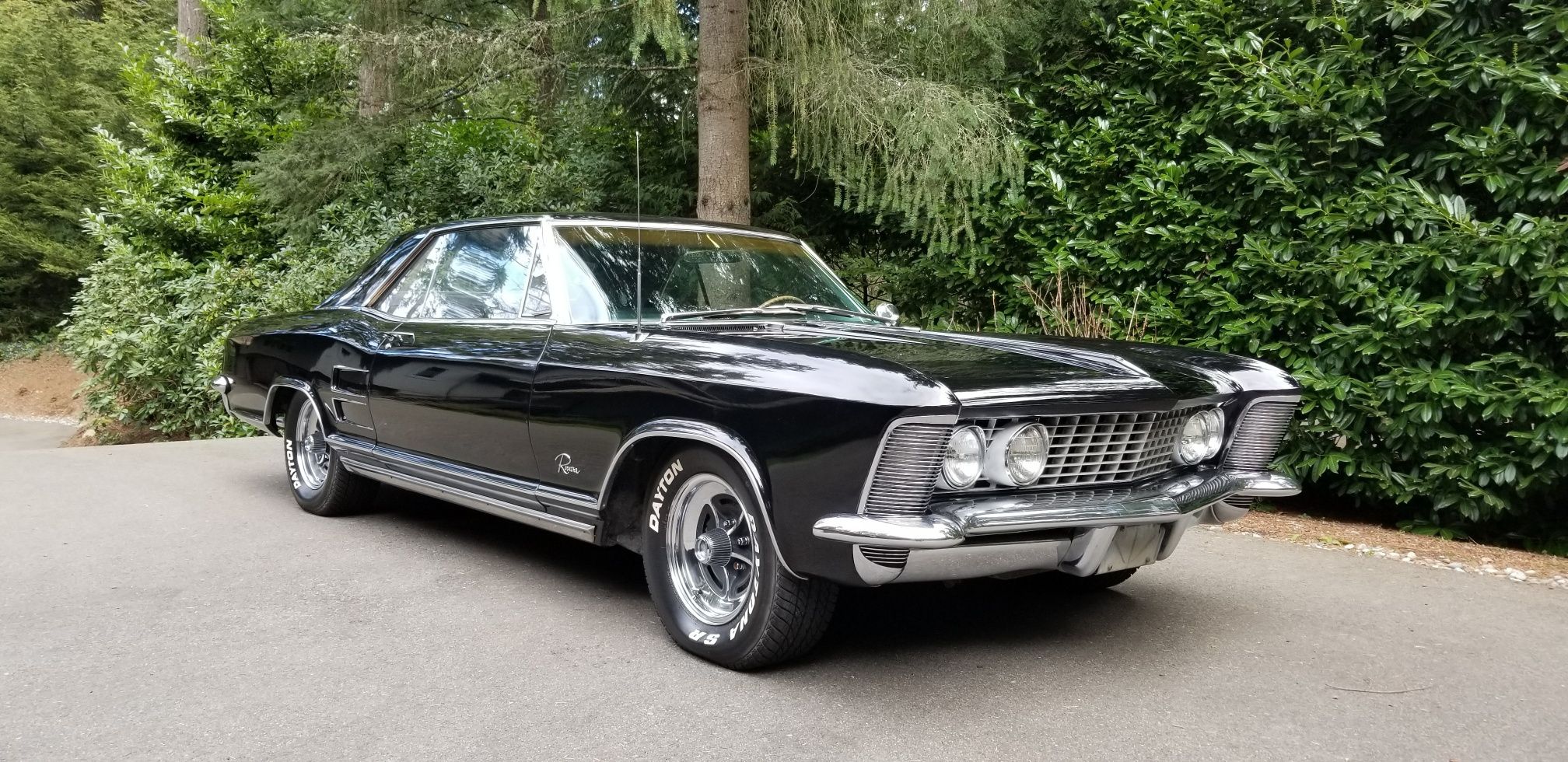 A black 1963 Buick Riviera is viewed from the front passenger side.
