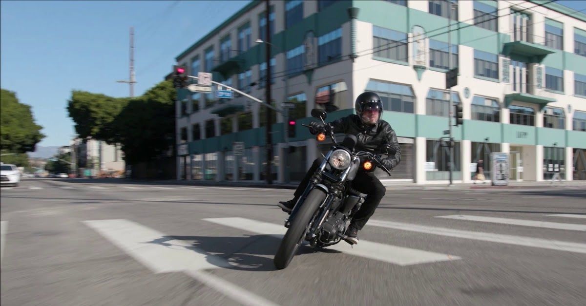 Man riding 2021 Harley-Davidson Iron 883 at intersection