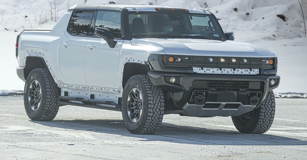2022 GMC Hummer EV Prototype driving on road bordered by snow