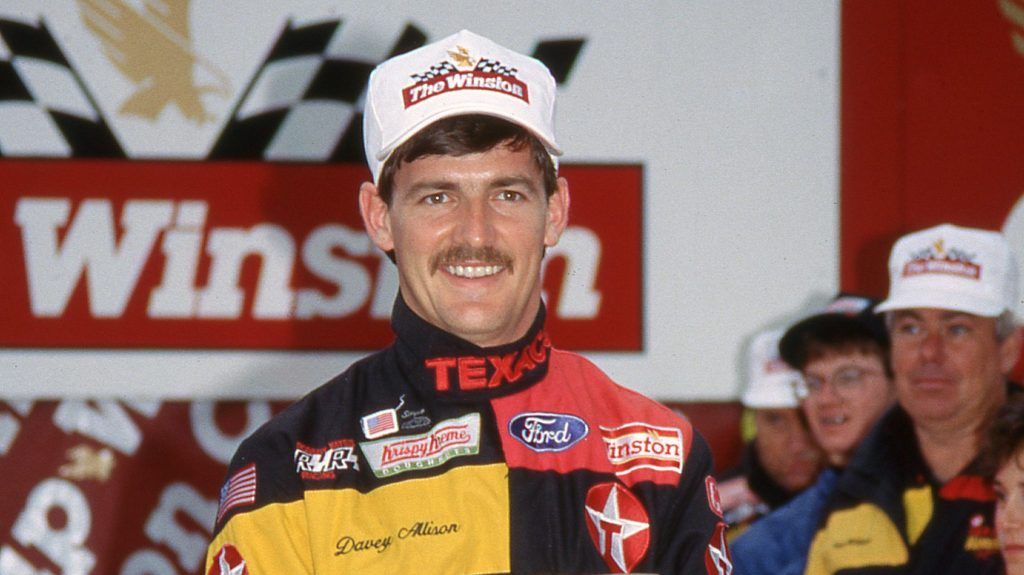 NASCAR Winston Cup Driver Davey Allison on stage in his driver's uniform.