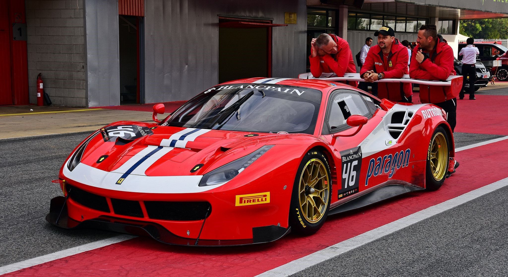 Ferrari drivers leaning on a race car