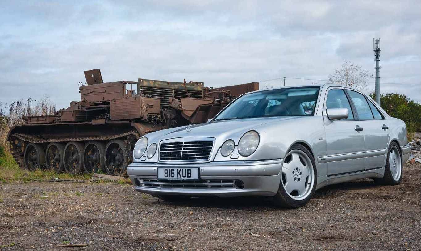Mercedes E55 AMG parked next to a tank