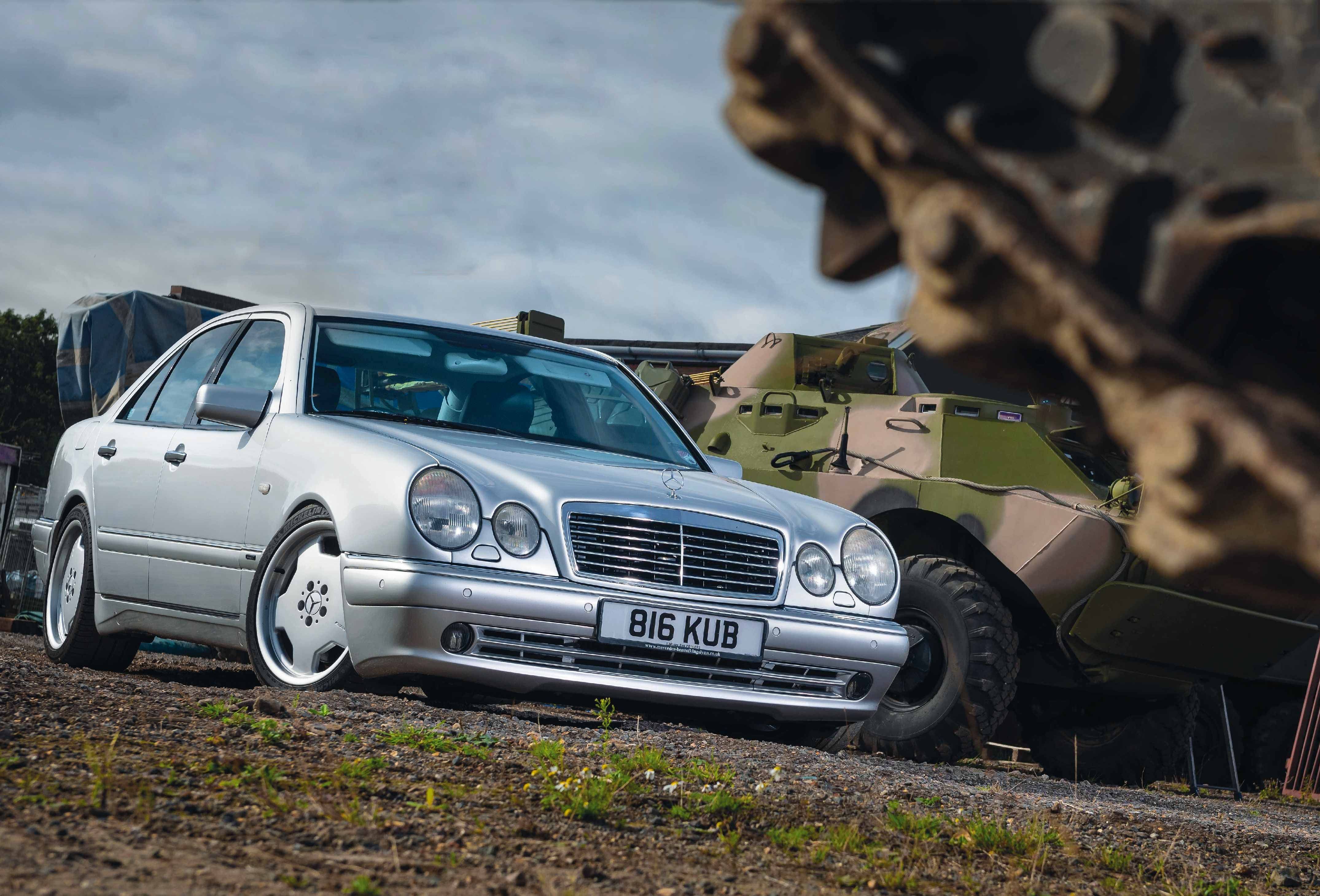 Mercedes E55 AMG parked next to a tank