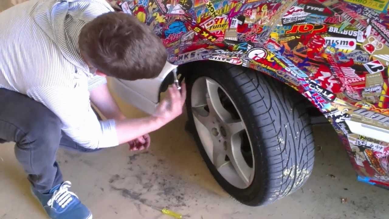 Man removing stickers from car