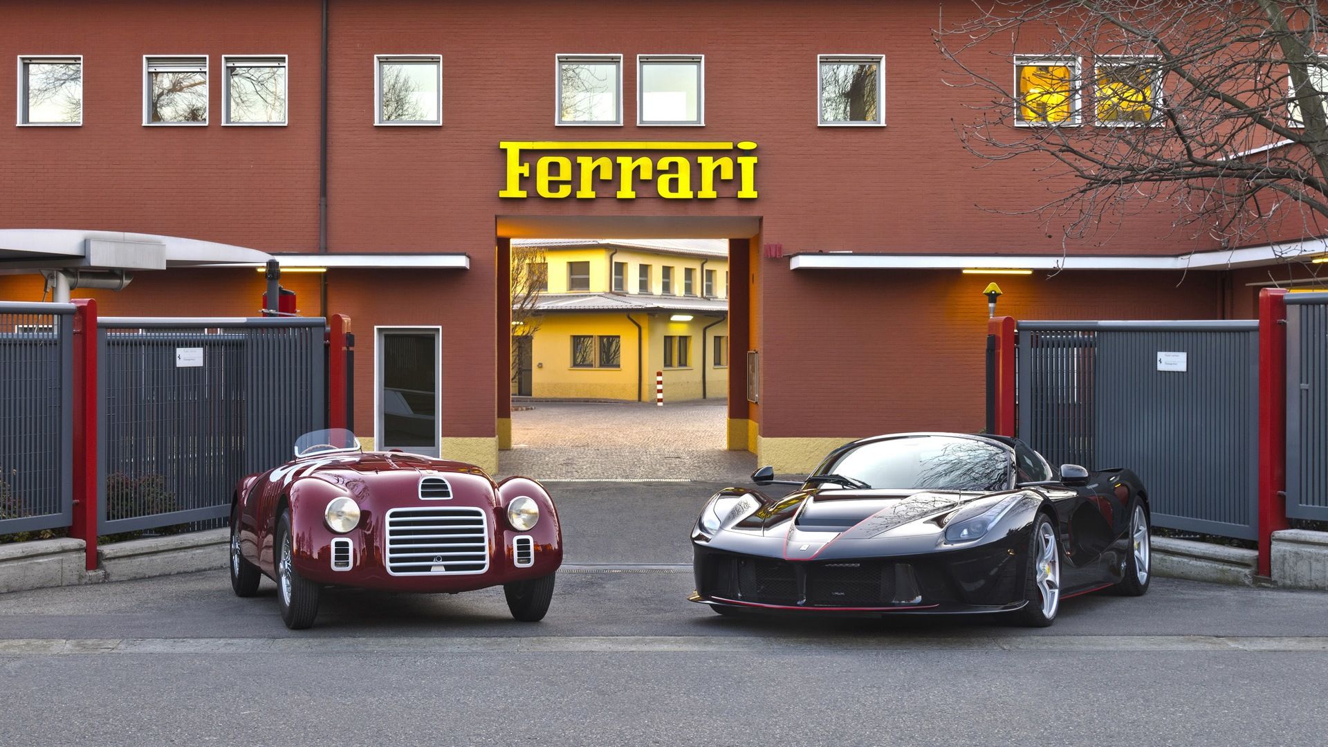 a classic Ferrari with a new ferrari outside Ferrari factory