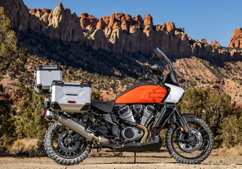 A 2021 Harley-Davidson Pan America parked beside a mountain range.