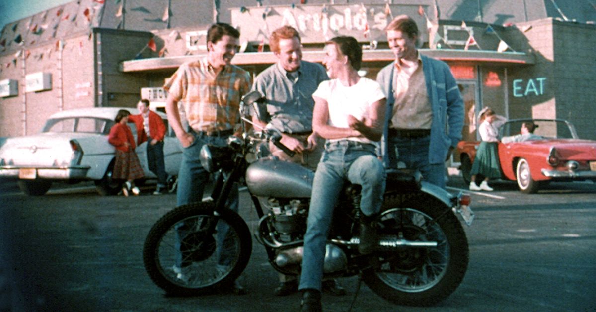 Fonzie et al. hang out around his Triumph motorcycle