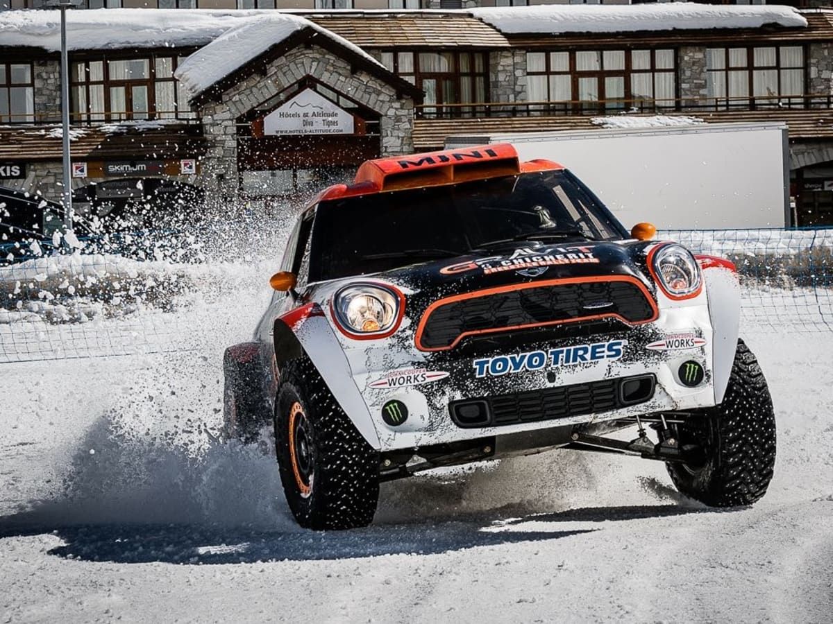 Mini skidding in snow in front of chalet
