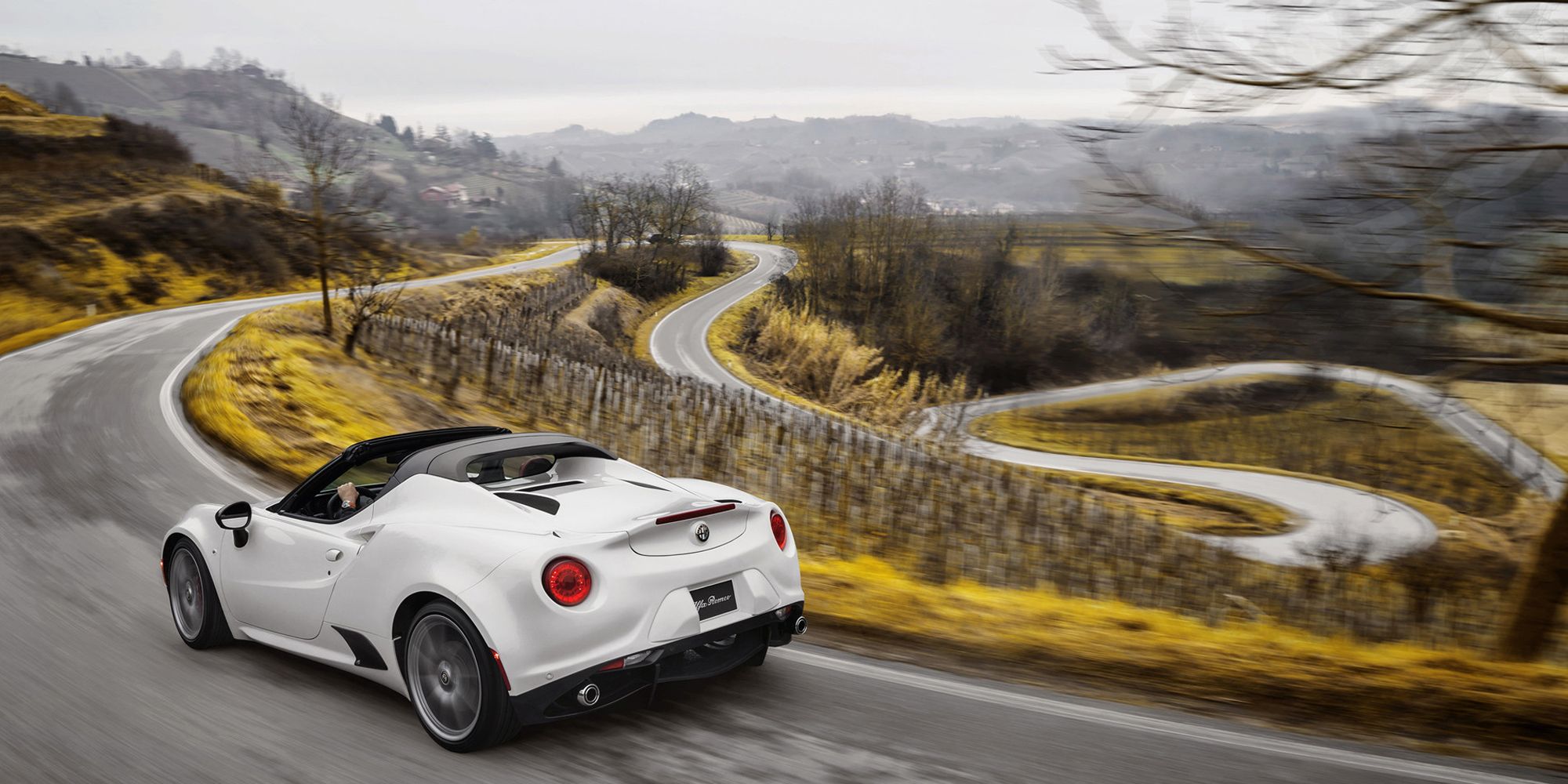 Rear 3/4 view of a white 4C Spider on the move