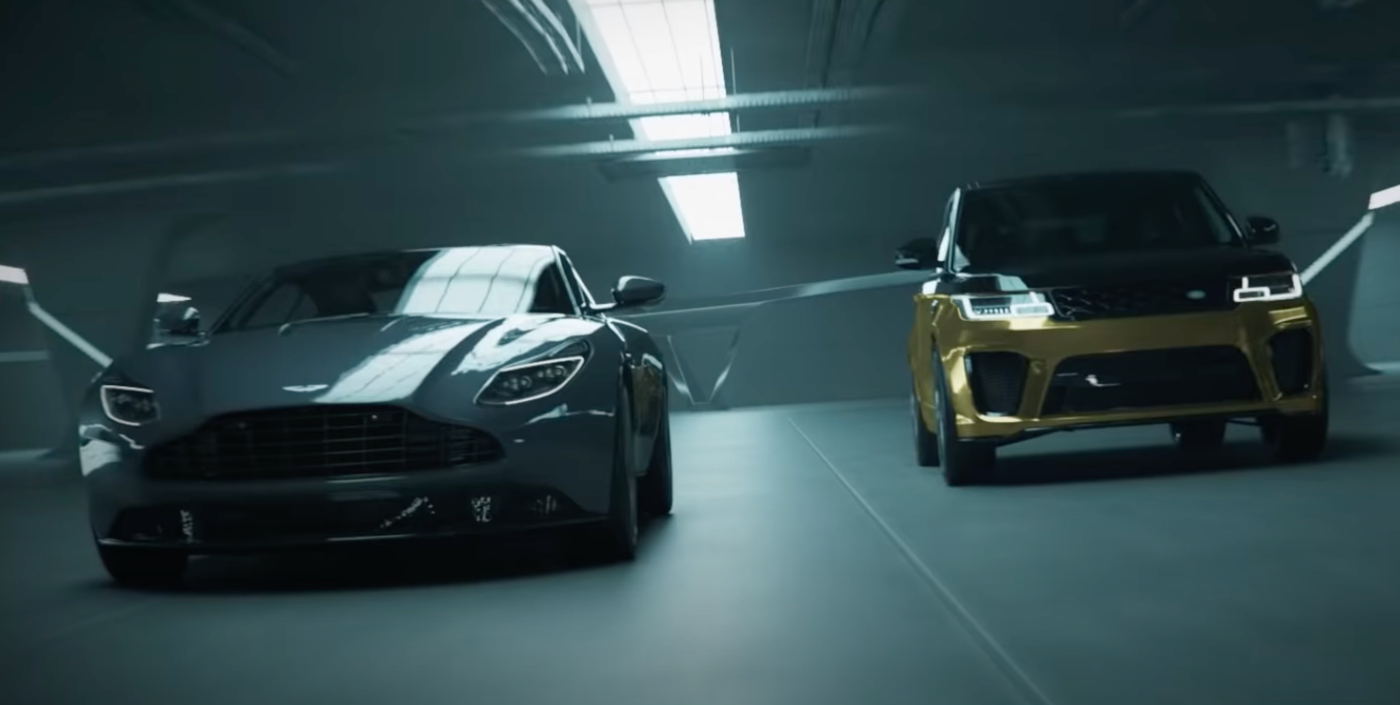 An Aston Martin and Range Rover in an underground parking garage.