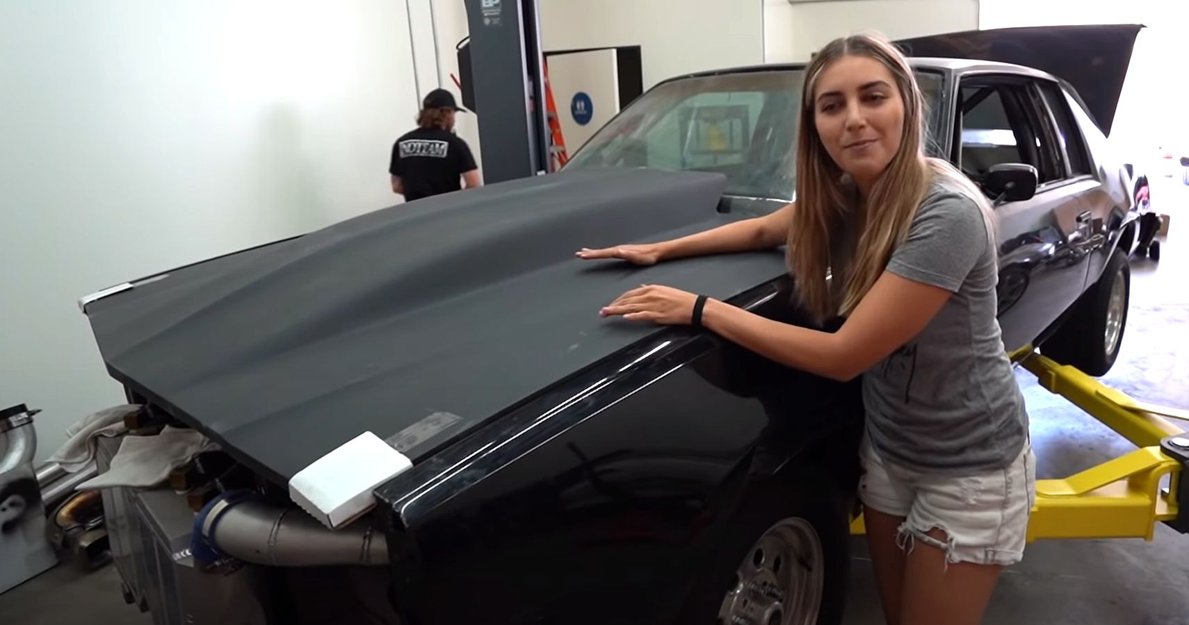 Emilia Hartford poses with Buick Regal in garage