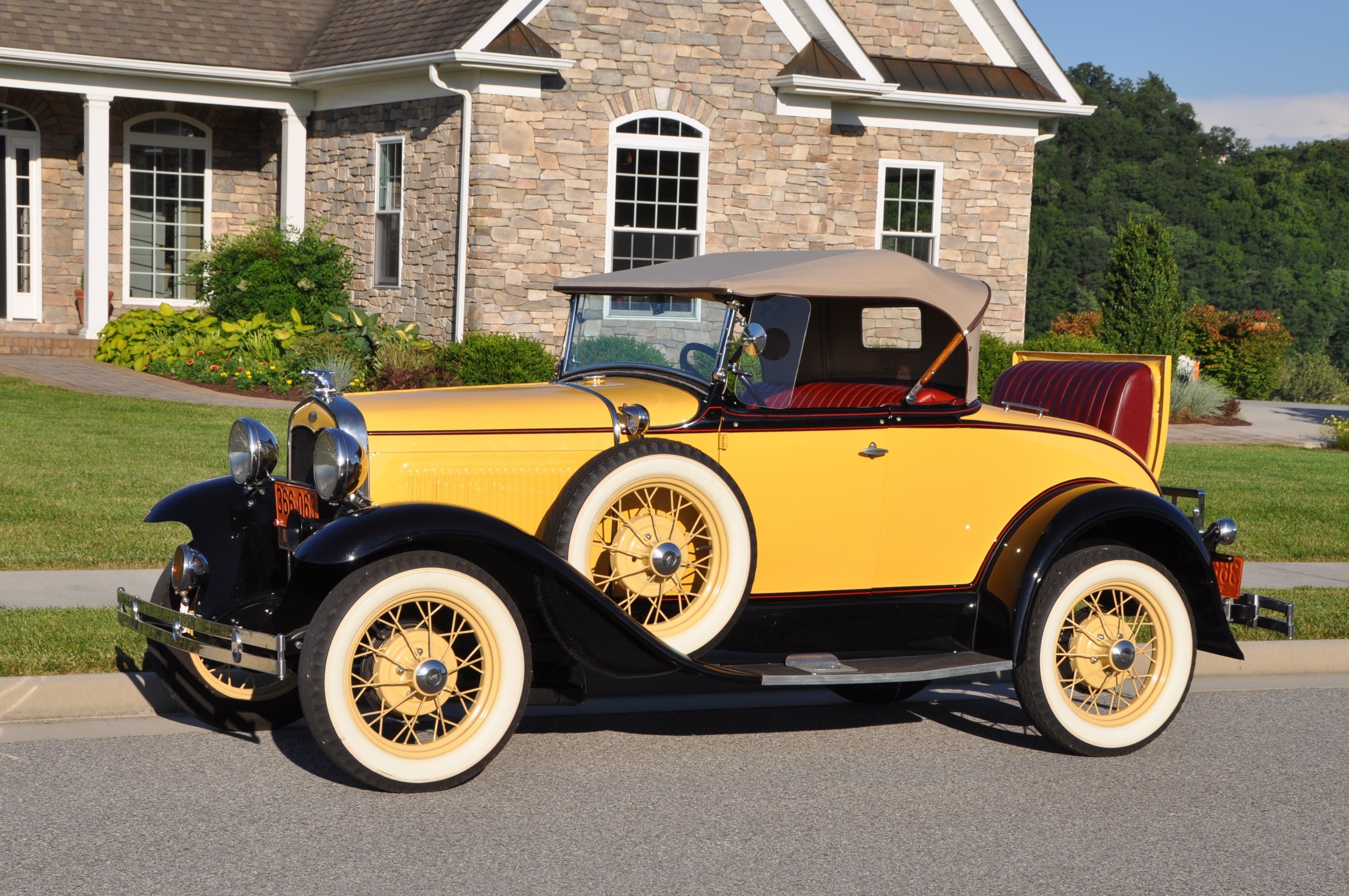Yellow Ford Model A parked in front of house
