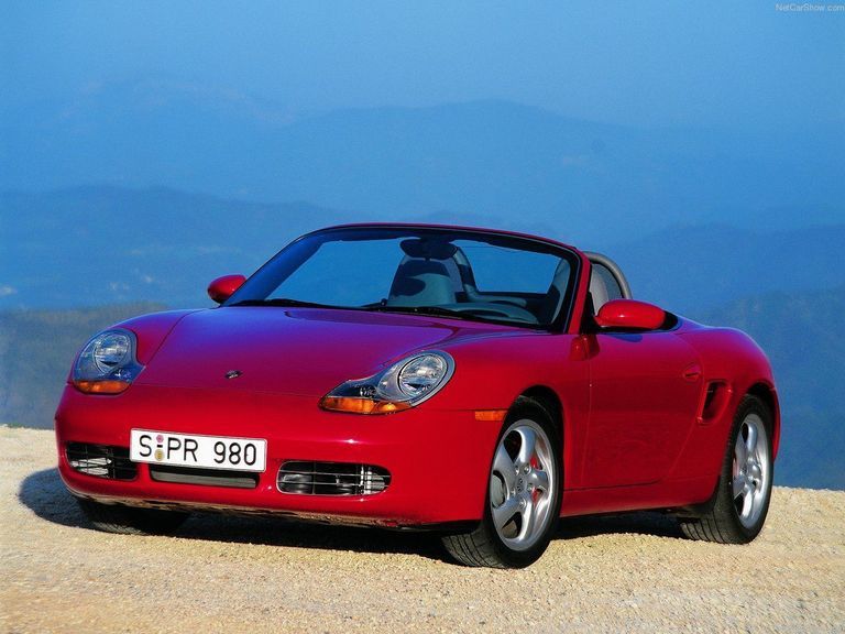 A red 2001 Porsche Boxster stands on top of a mountain.