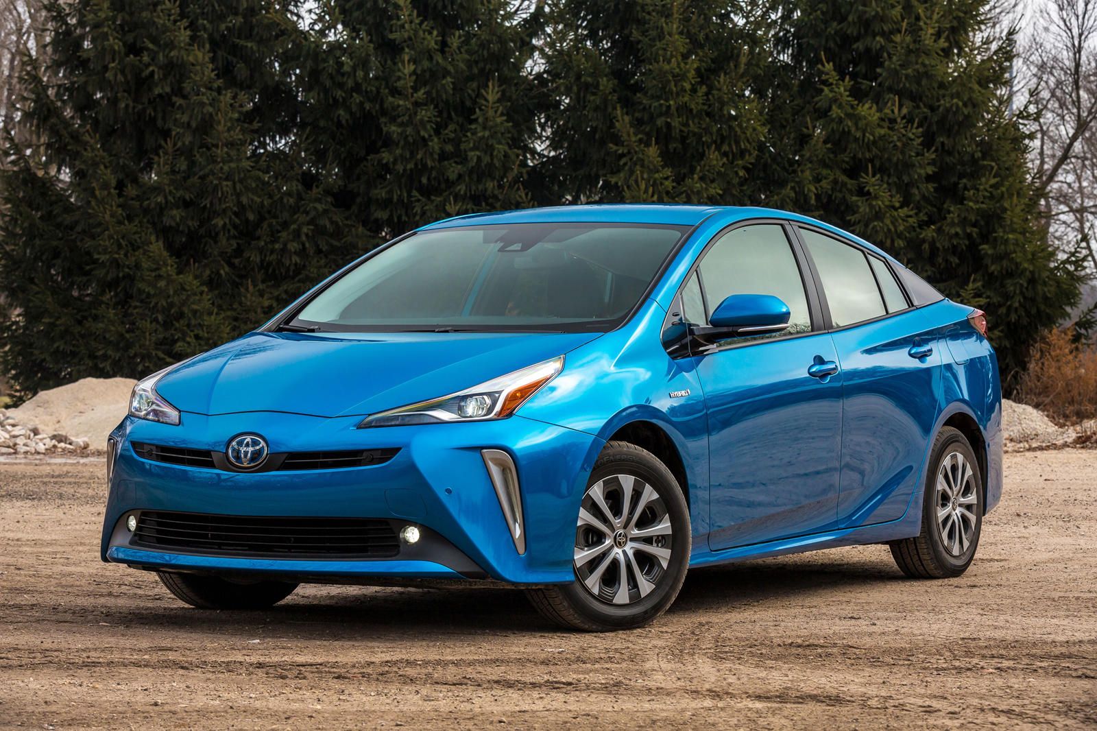 A blue 2019 Toyota Prius stands parked on a road.