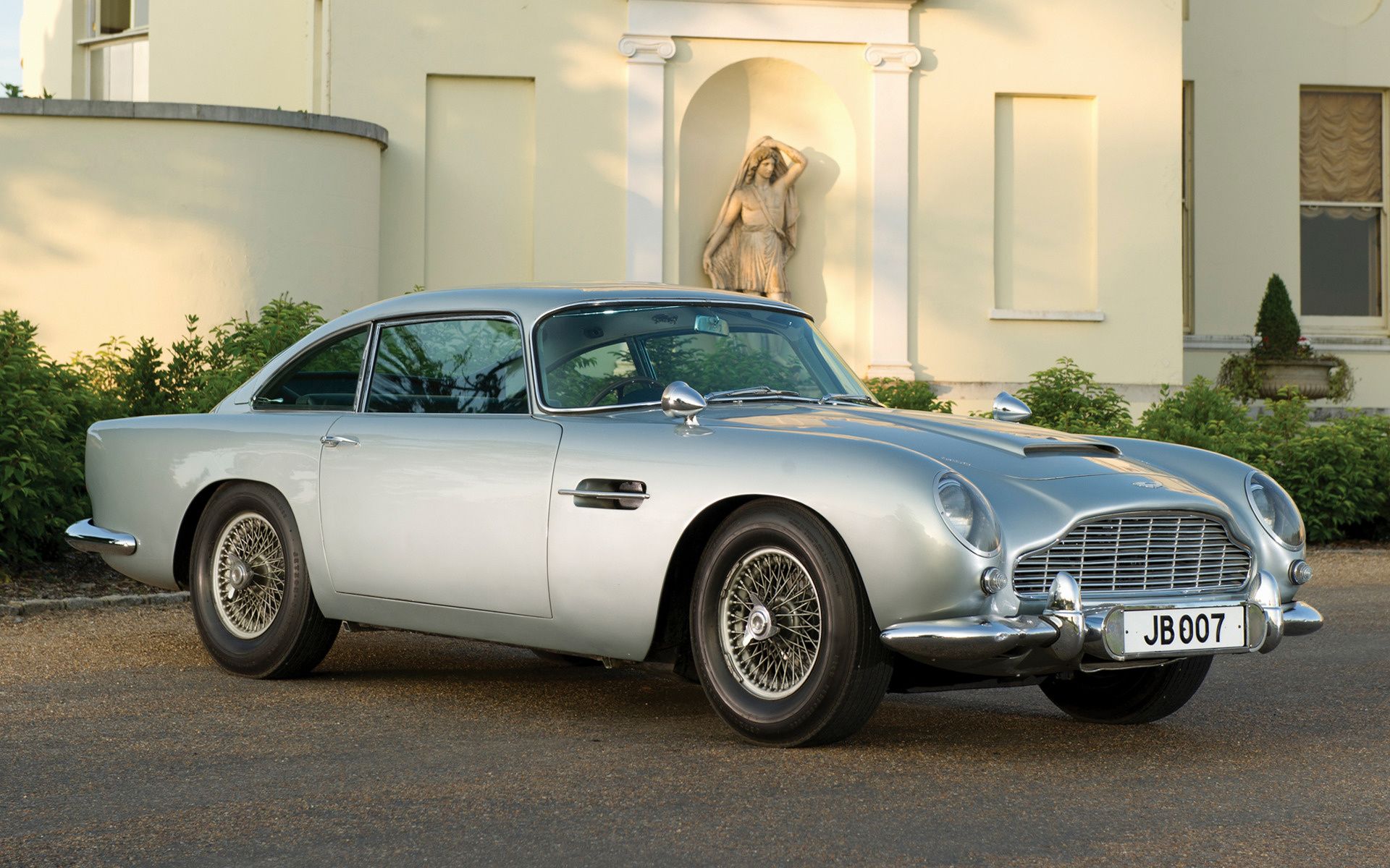 An Image Of A Silver Aston Martin DB5 On The Street