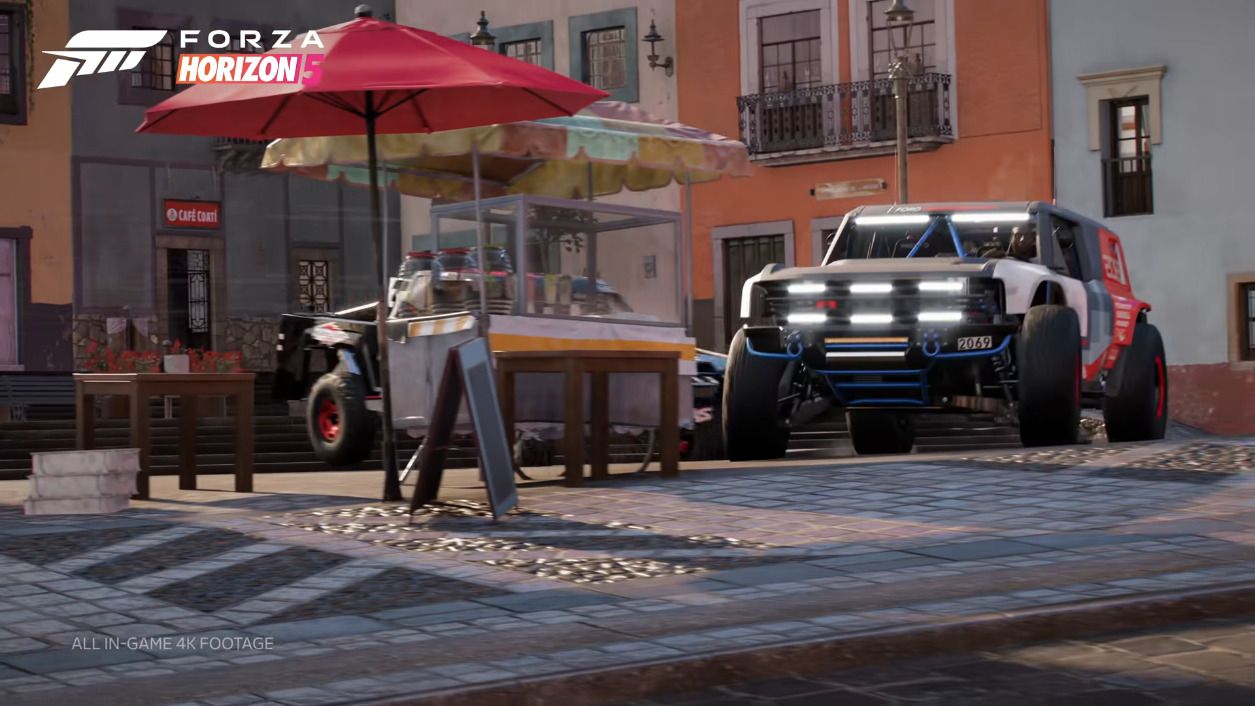 Two offroad vehicles smashing through a food stand