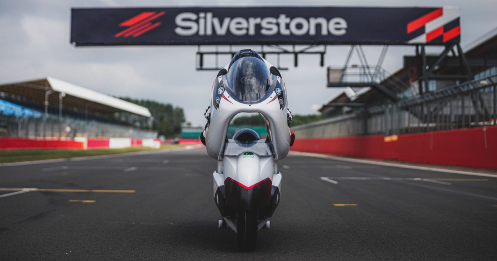 A rider on the White Motorcycle Concepts WMC250EV at Silverstone.